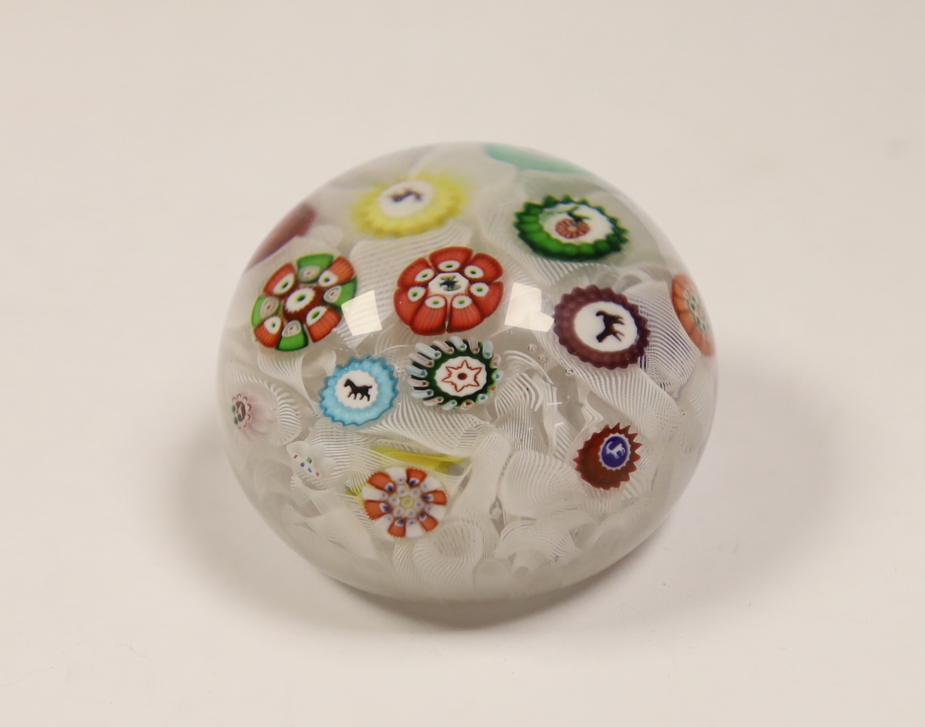 A Baccarat glass paperweight with scattered silhouette and other canes on a quilted latticino ground, dated B1848, 5.2cm